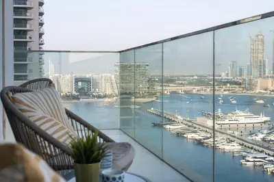 a balcony with a view of a harbor and boats at 4BR Beachfront Marina & Palm View in Dubai