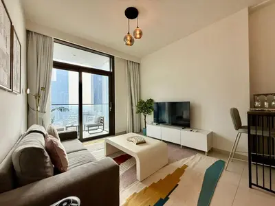 a living room with a couch and a tv at Cozy 1BR Burj Crown Downtown in Dubai