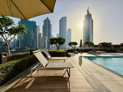 a swimming pool with a bench and a city skyline at Cozy 1BR Burj Crown Downtown in Dubai