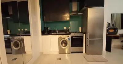 a kitchen with a washing machine and a washer at Capital Bay city view Studio in Dubai