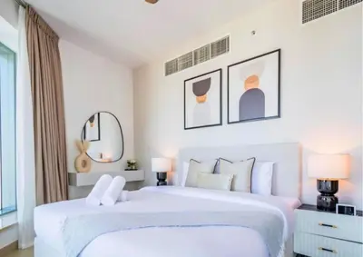 a white bedroom with two beds and a mirror at Exceptional 1BR I Burj Khalifa I Fountain View in Dubai