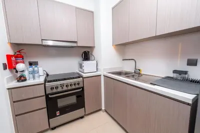 a small kitchen with a stove and a sink at Downtown Escape 2bedroom Apartment 4 guests Dubai in Dubai