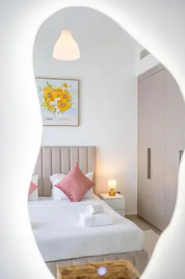 a bedroom with a white bed with pink pillows at Downtown Escape 2bedroom Apartment 4 guests Dubai in Dubai