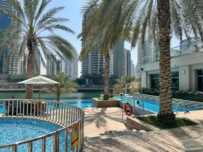 a swimming pool with palm trees in a city at Apartments on Marina in Dubai