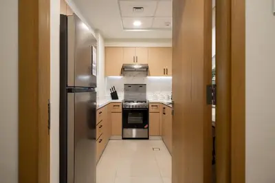 a kitchen with a stove and a refrigerator at Elegant 3-Bedroom Apartment - Panoramic Burj Khalifa and Downtown Views in Dubai