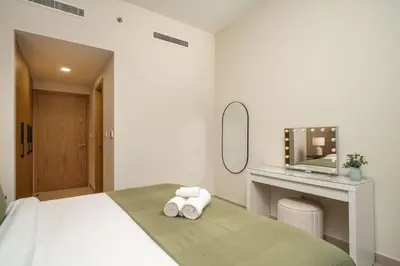 a bedroom with a bed with a mirror and towels at Elegant 3-Bedroom Apartment - Panoramic Burj Khalifa and Downtown Views in Dubai