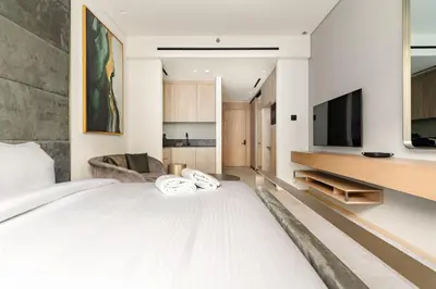 a bedroom with a white bed and a tv at Modern Studio Near Burj Khalifa & Dubai Mall with Pool, Gym, Concierge & Parking in Dubai