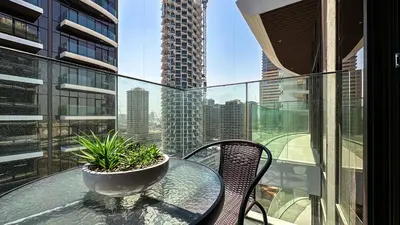 a glass table with a potted plant on a balcony at Modern Studio in JVC, Rooftop Pool & Gym Access - 10AB08 in Dubai