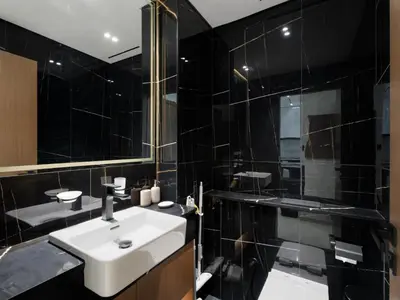 a black bathroom with a sink and a mirror at Luxe Escape - Stylish 1BR in Binghatti Venus-05 in Dubai