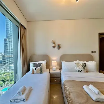 two beds in a room with a window at Grande Signature Burj Khalifa view 4 Min walk Dubai Mall Infinity Pool with Fountain View Free parking By The Meridian in Dubai