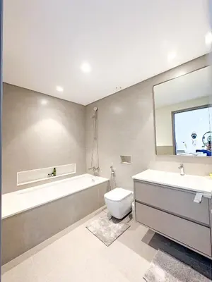 a bathroom with a tub and a toilet and a sink at Grande Signature Burj Khalifa view 4 Min walk Dubai Mall Infinity Pool with Fountain View Free parking By The Meridian in Dubai