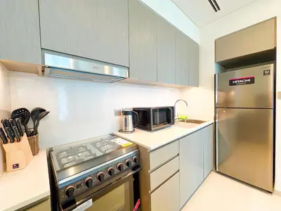 a kitchen with a stainless steel refrigerator and a microwave at Grande Signature Burj Khalifa view 4 Min walk Dubai Mall Infinity Pool with Fountain View Free parking By The Meridian in Dubai