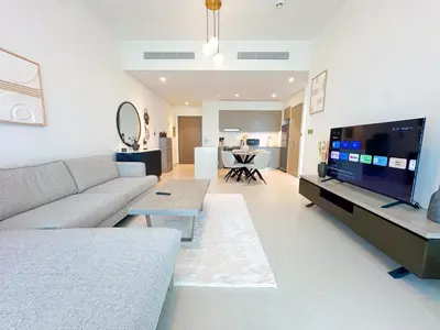 a living room with a couch and a flat screen tv at Grande Signature Burj Khalifa view 4 Min walk Dubai Mall Infinity Pool with Fountain View Free parking By The Meridian in Dubai