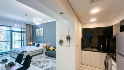 a room with a bed and a living room with a kitchen at Cozy Studio with Balcony Overlooking Dubai Canal - 15AB07 in Dubai