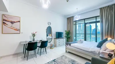 a bedroom with a bed and a desk with chairs at Cozy Studio with Balcony Overlooking Dubai Canal - 15AB07 in Dubai