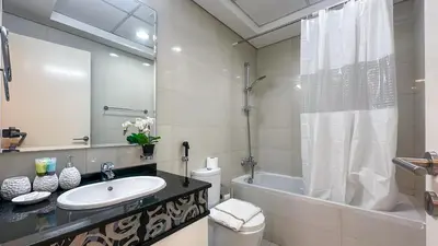 a bathroom with a sink and a tub and a toilet at Cozy Studio with Balcony Overlooking Dubai Canal - 15AB07 in Dubai