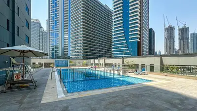 a swimming pool in a city with tall buildings at Cozy Studio with Balcony Overlooking Dubai Canal - 15AB07 in Dubai