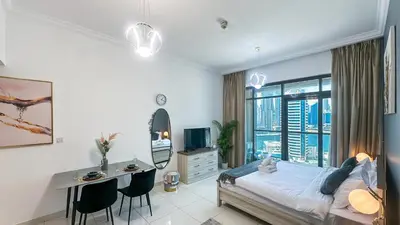 a bedroom with a bed and a desk and a deskablish at Cozy Studio with Balcony Overlooking Dubai Canal - 15AB07 in Dubai