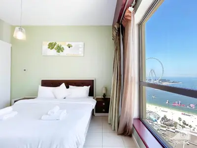 a bedroom with two beds and a large window at Stunning 4 bedroom with Breathtaking Sea View JBR in Dubai