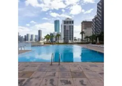 a large swimming pool with a city in the background at Luxury 2-Bedroom Stay in the Heart of Churchill in Dubai