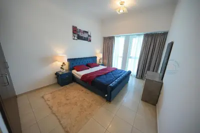 a bedroom with a blue bed and a window at Luxury 2-Bedroom Stay in the Heart of Churchill in Dubai