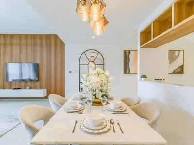 a dining room table with chairs and a vase of flowers at TRPS - Downtown Views II Tower 2, Downtown Dubai - 3BR plus Maids - Stylish Apartment Near Burj Khalifa & Attractions in Dubai