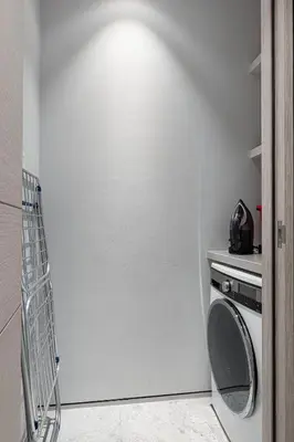 a white laundry room with a washing machine in it at SkyHigh Stay, Panoramic Sea Views & Beach Access in Dubai