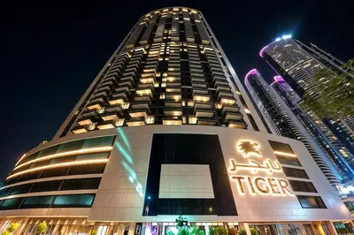 a tall building with a sign on it at night at Nobles Tower tiger one skyline view in Dubai