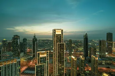 a view of a large city at night at Luxury 2BR Sea View Walk to Burj & Dubai Mall in Dubai