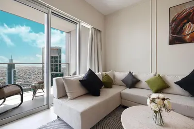 a living room with a couch and a large window at Luxury 2BR Sea View Walk to Burj & Dubai Mall in Dubai