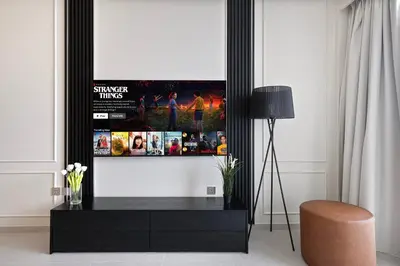 a living room with a flat screen tv on a wall at Luxury 2BR Sea View Walk to Burj & Dubai Mall in Dubai