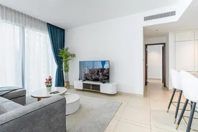 a living room with a couch and a tv at Contemporary Comfort - Serenity - Pool View in Dubai
