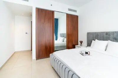 a bedroom with a large bed and a mirror at Contemporary Comfort - Serenity - Pool View in Dubai