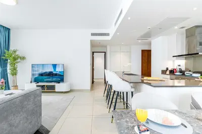 a kitchen and living room with a table and chairs at Contemporary Comfort - Serenity - Pool View in Dubai