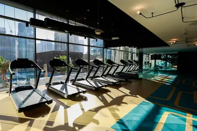 a row of exercise bikes in a building with windows at Contemporary Comfort - Serenity - Pool View in Dubai