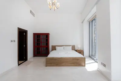 a white bedroom with a bed and a window at Cayan Tower Dubai Marina - Mint Stay in Dubai