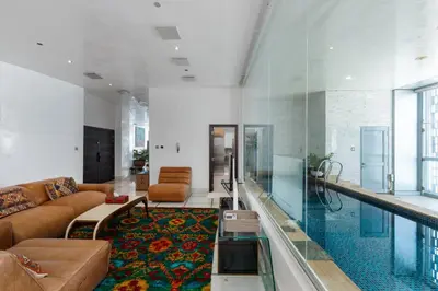a living room with a couch and a swimming pool at Cayan Tower Dubai Marina - Mint Stay in Dubai