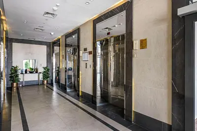 a hallway of a building with glass doors at Cozy And Contemporary Studio In Dubailand in Dubai