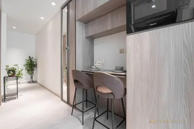 a kitchen with a bar with stools and a television at Contemporary Studio Terrace Luxe & Secure Stay in Dubai