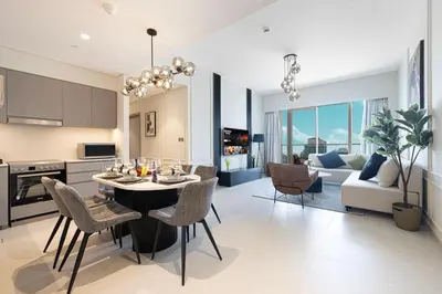 a kitchen and living room with a table and chairs at Luxury2BR Sea View Hot Tub Walk to Burj Dubai Mall in Dubai