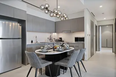 a kitchen with a table with chairs and a refrigerator at Luxury2BR Sea View Hot Tub Walk to Burj Dubai Mall in Dubai