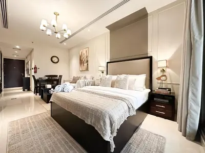 a bedroom with a large bed and a living room at Modern Studio Downtown Dubai Luxury & Convenience in Dubai