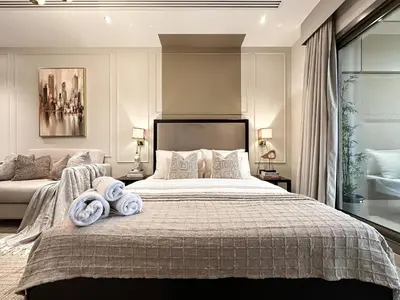 a bedroom with a large bed with towels on it at Modern Studio Downtown Dubai Luxury & Convenience in Dubai