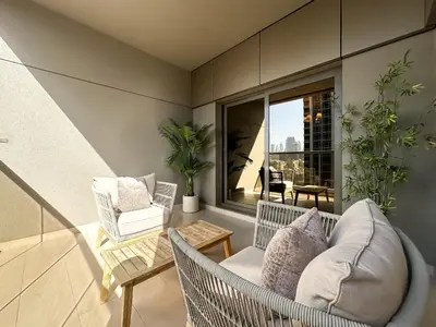 a living room with a couch and chairs on a balcony at Modern Studio Downtown Dubai Luxury & Convenience in Dubai