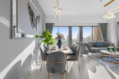 a living room with a table and chairs at Stunning 3BR Burj Fountain view & Dubai Mall in Dubai