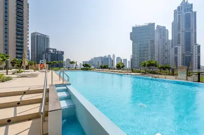 a swimming pool with a city skyline in the background at Stylish 2BR with Boulevard View & 5 min from Dubai Mall in Dubai