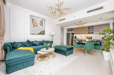 a living room with a blue couch and a kitchen at Stylish 2BR with Boulevard View & 5 min from Dubai Mall in Dubai