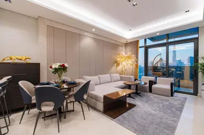 a living room with a couch and a table and chairs at Full Burj khalifa view 41 Floor in Dubai