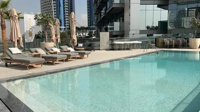 a large swimming pool with lounge chairs and a building at Full Burj khalifa view 41 Floor in Dubai