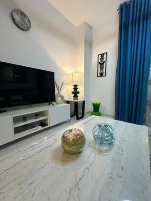 a living room with a television and a table with a bowl at C Infinity Holiday Homes in Dubai Marina in Dubai